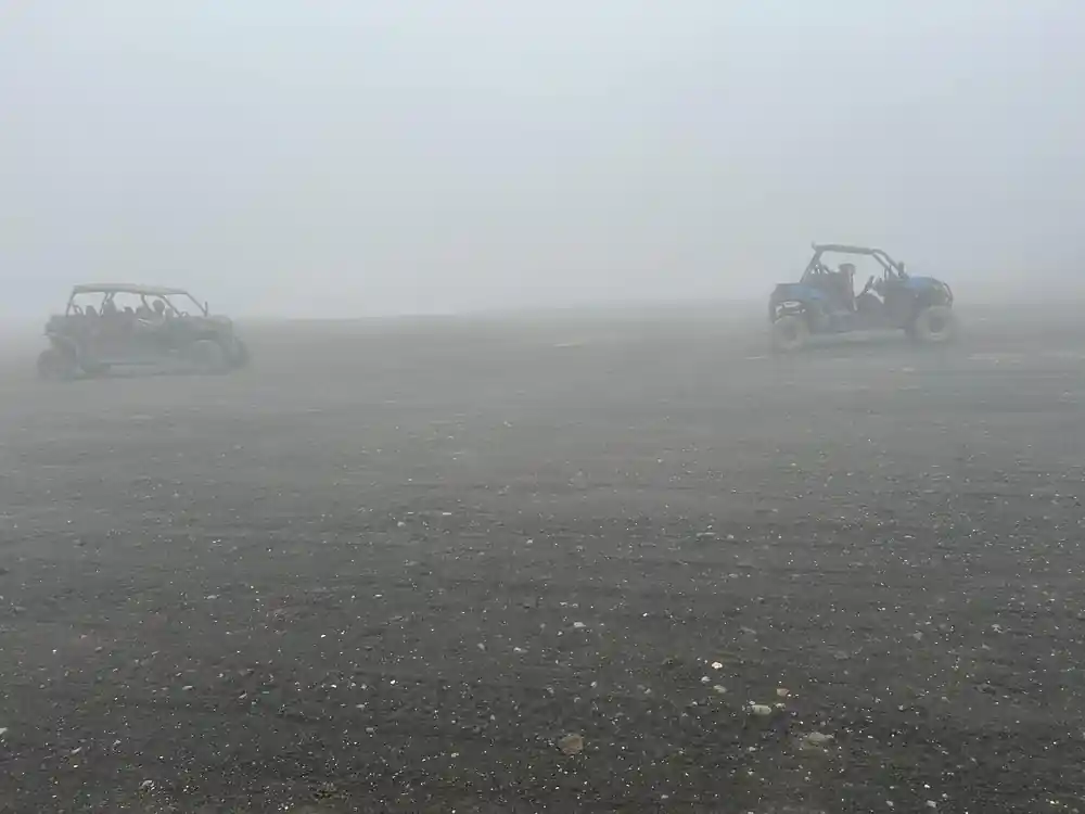 All-terrain vehicles in thick fog on dark ground