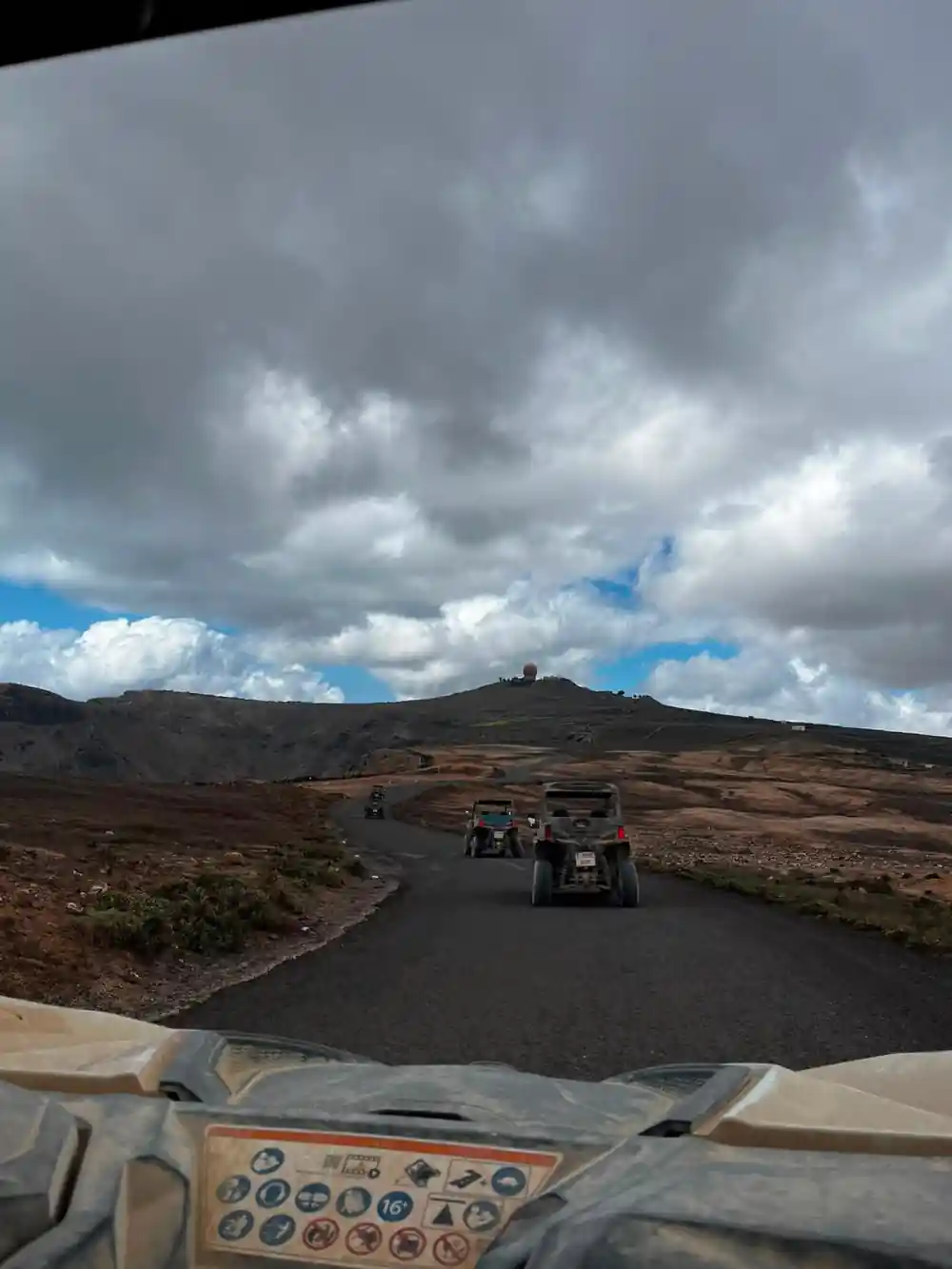 Buggy convoy driving on dark volcanic road