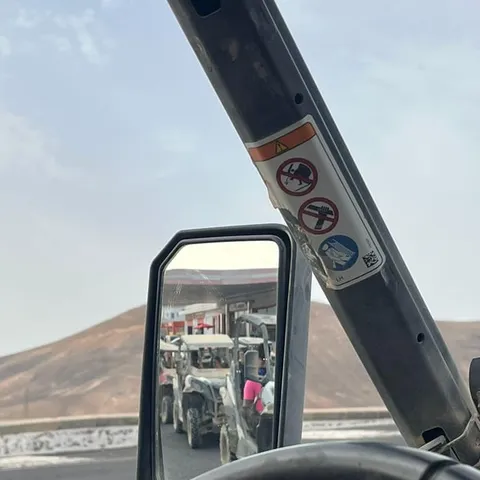 A buggy convoy seen in the wing mirror