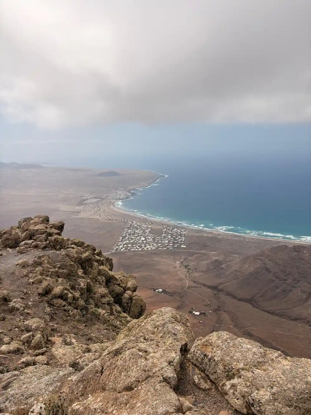 Coastal landscape with beach town and ocean from cliff viewpoint