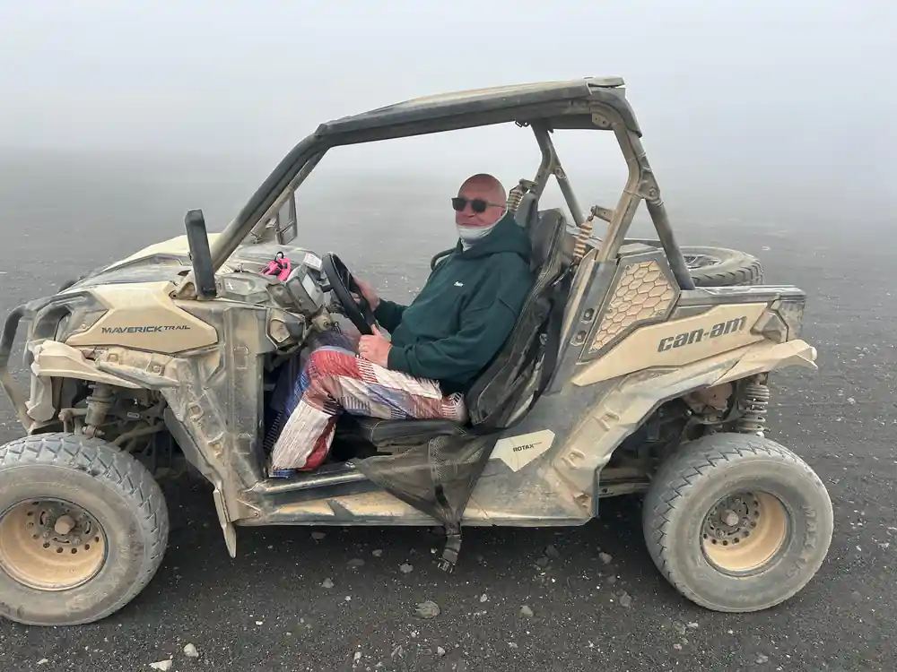 Person in all-terrain vehicle on black volcanic rock
