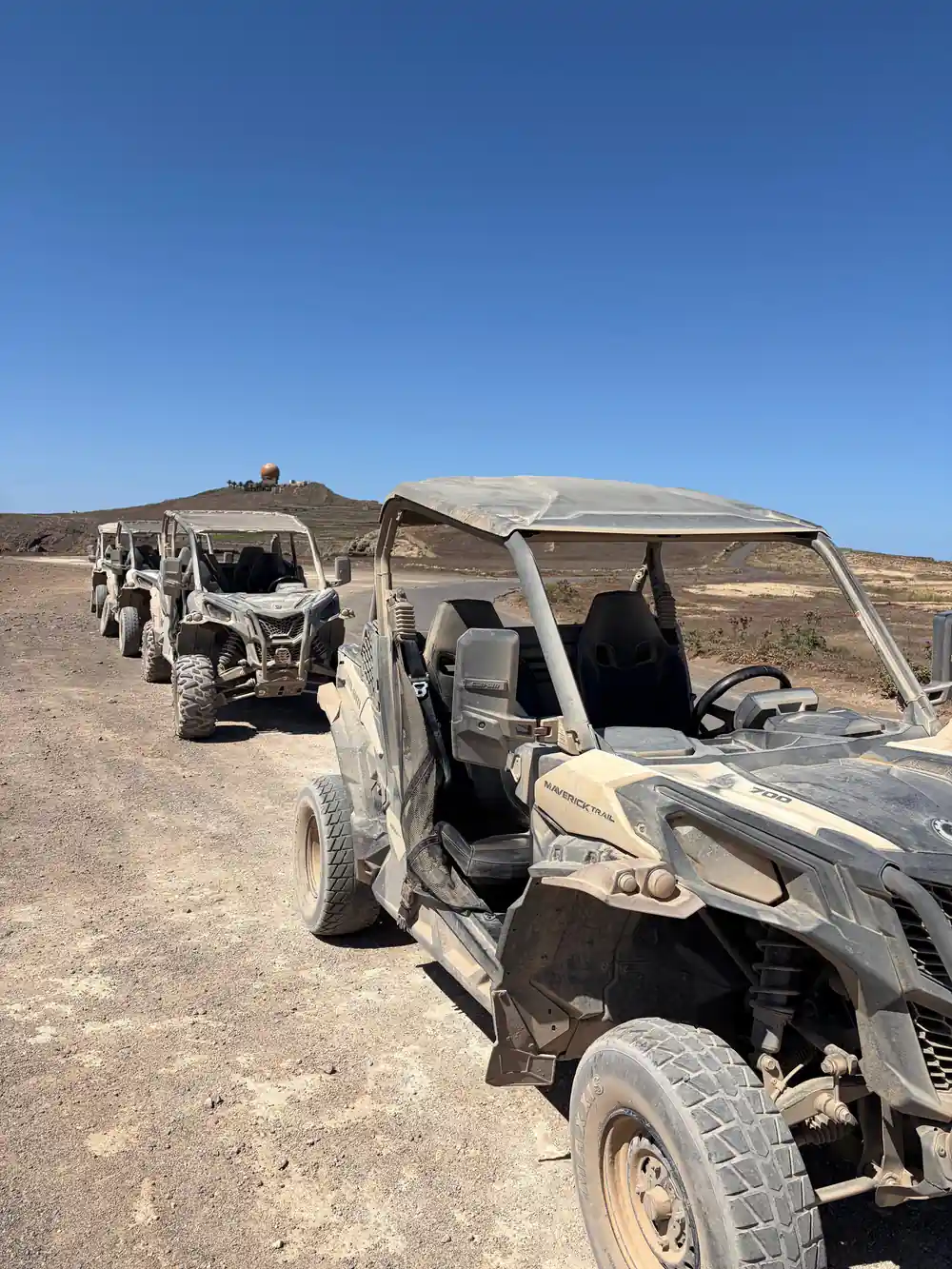 Row of damaged buggies parked in arid landscape