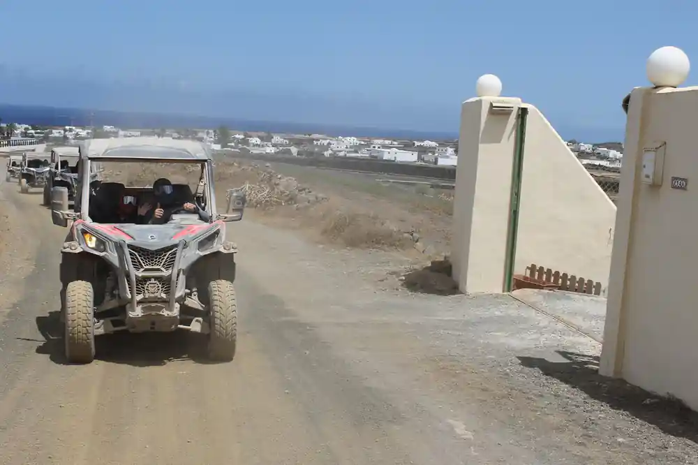 White buggy parked on dirt road near buildings